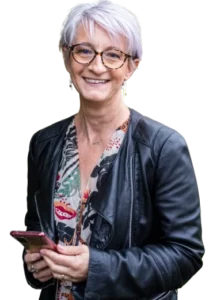 photo d'une femme souriante avec blouson en cuir noir et tenant un smartphone représentant Laurence Fauché-Nicoleau - La Griffe Éditoriale