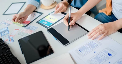 Visuel présentant deux personnes travaillant sur la conception d'un site Web pour illustrer le paragraphe "pourquoi un site Web sur mesure ?" sur la page d'accueil du site La Griffe Éditoriale - Sites Web sur mesure à Bordeaux