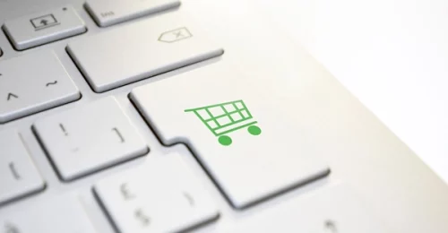 Photo d'un clavier d'ordinateur avec un caddy à la place de la touche "entrer" pour illustrer le paragraphe "Un site Web pour élargir votre clientèle, ici et ailleurs" de l'article "à quoi sert un site web pour votre entreprise ?"